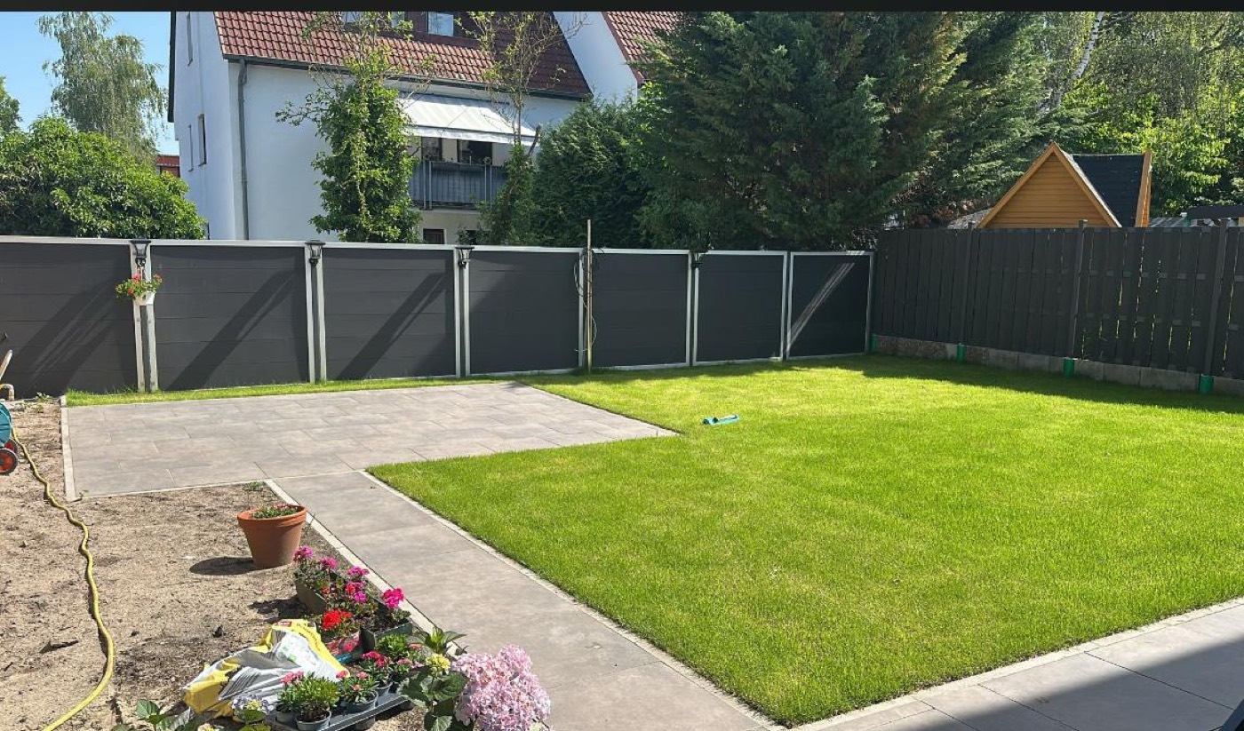 Neu angelegte Gartenanlage mit Rollrasen, Pflasterweg und Sichtschutzzaun von Stein Profi